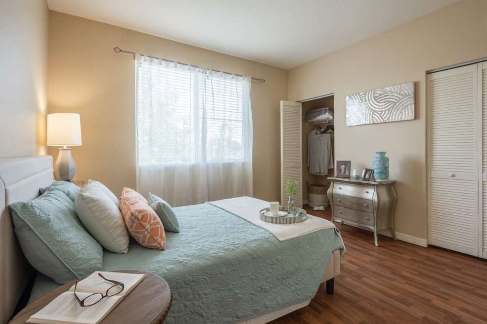 Comfortable bedroom with king size bed, closet and wood-style flooring at Grand Villa of Ocala in Ocala, Florida
