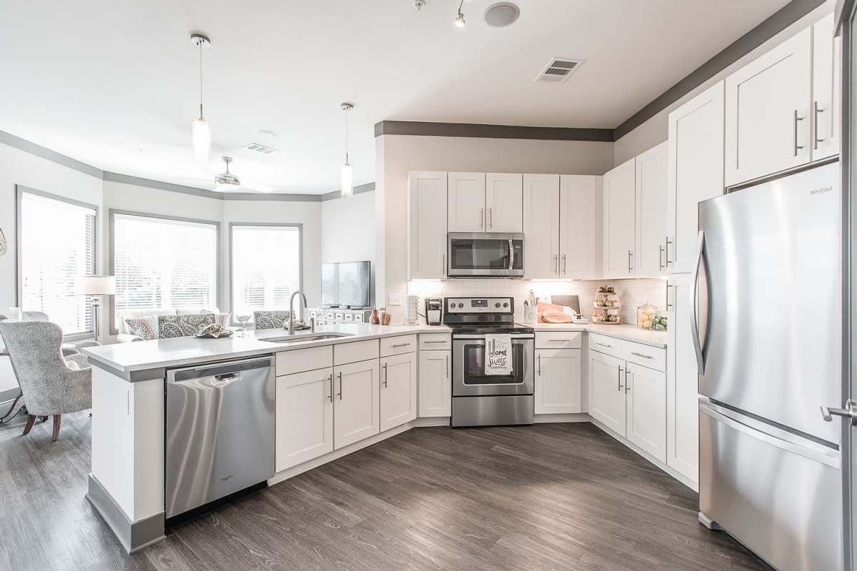 Modern kitchen with stainless-steel appliances and wood-style flooring at Vintage at the Avenue, Murfreesboro, Tennessee