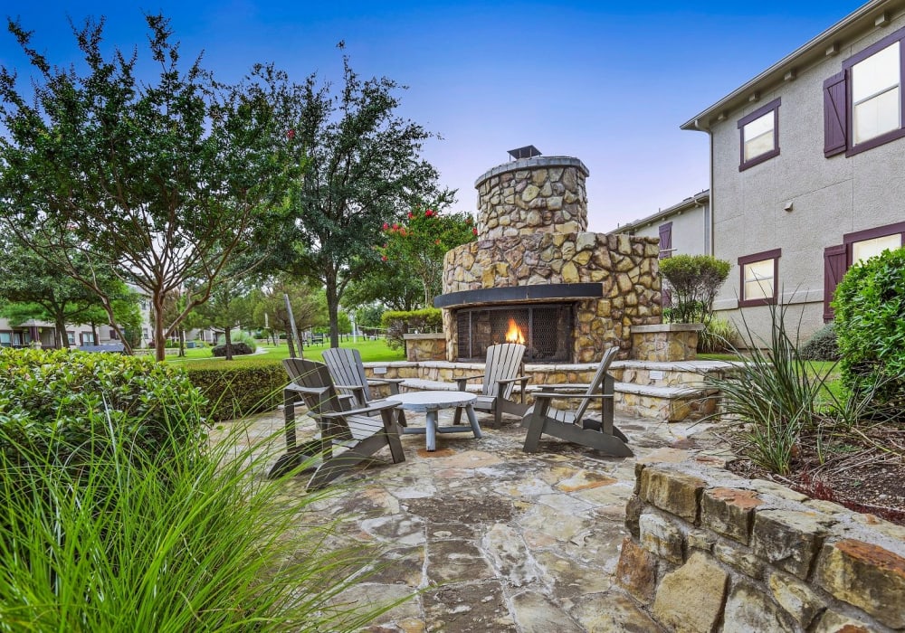 Outdoor stone-wall fire pit with seating at Ranch ThreeOFive in Arlington, Texas