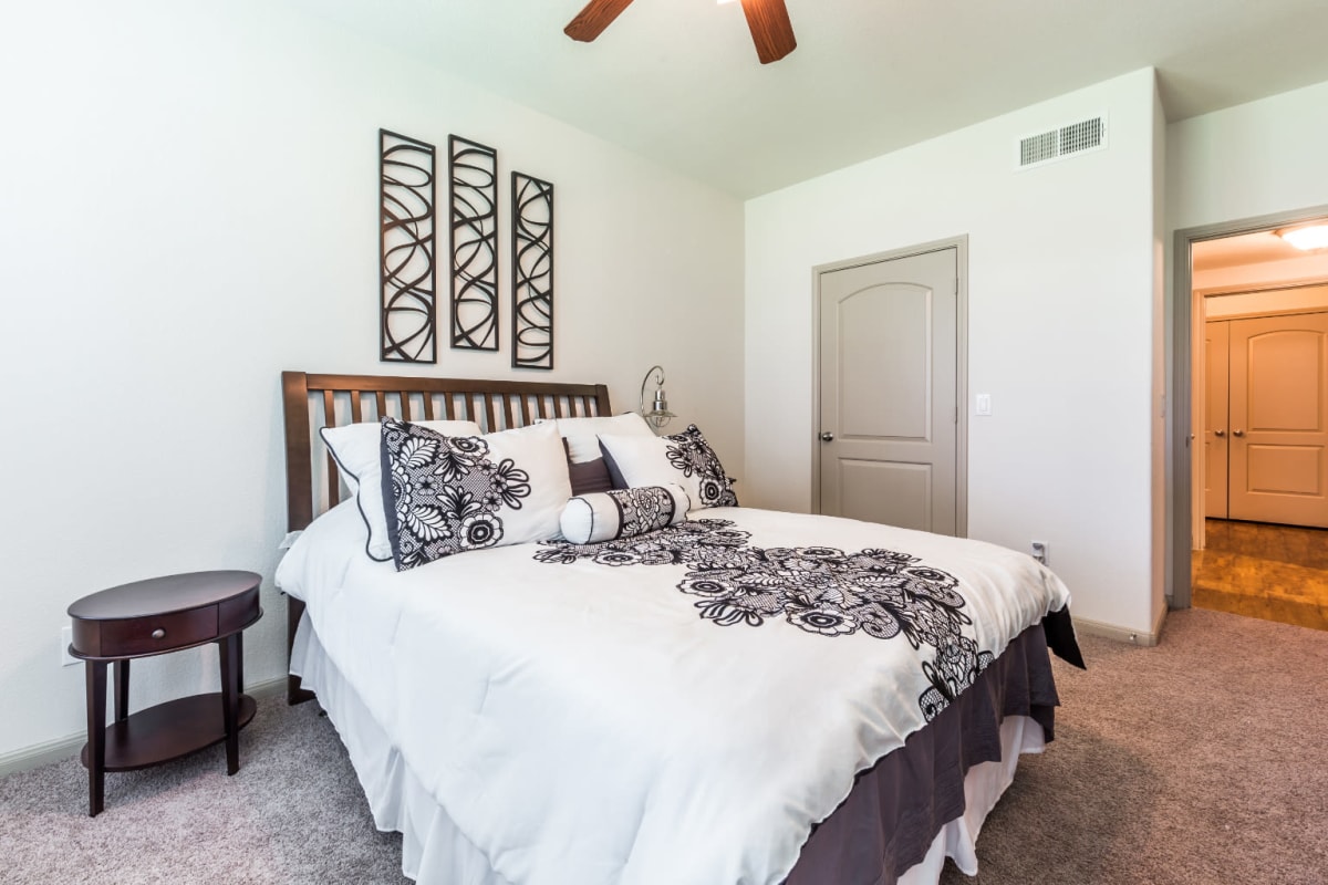 Carpeted bedroom with walk-in closet at Marquis at Clear Lake in Webster, Texas