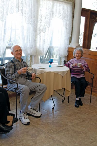 Resident couple sitting and drinking tea at Quail Park of Granbury in Granbury, Texas
