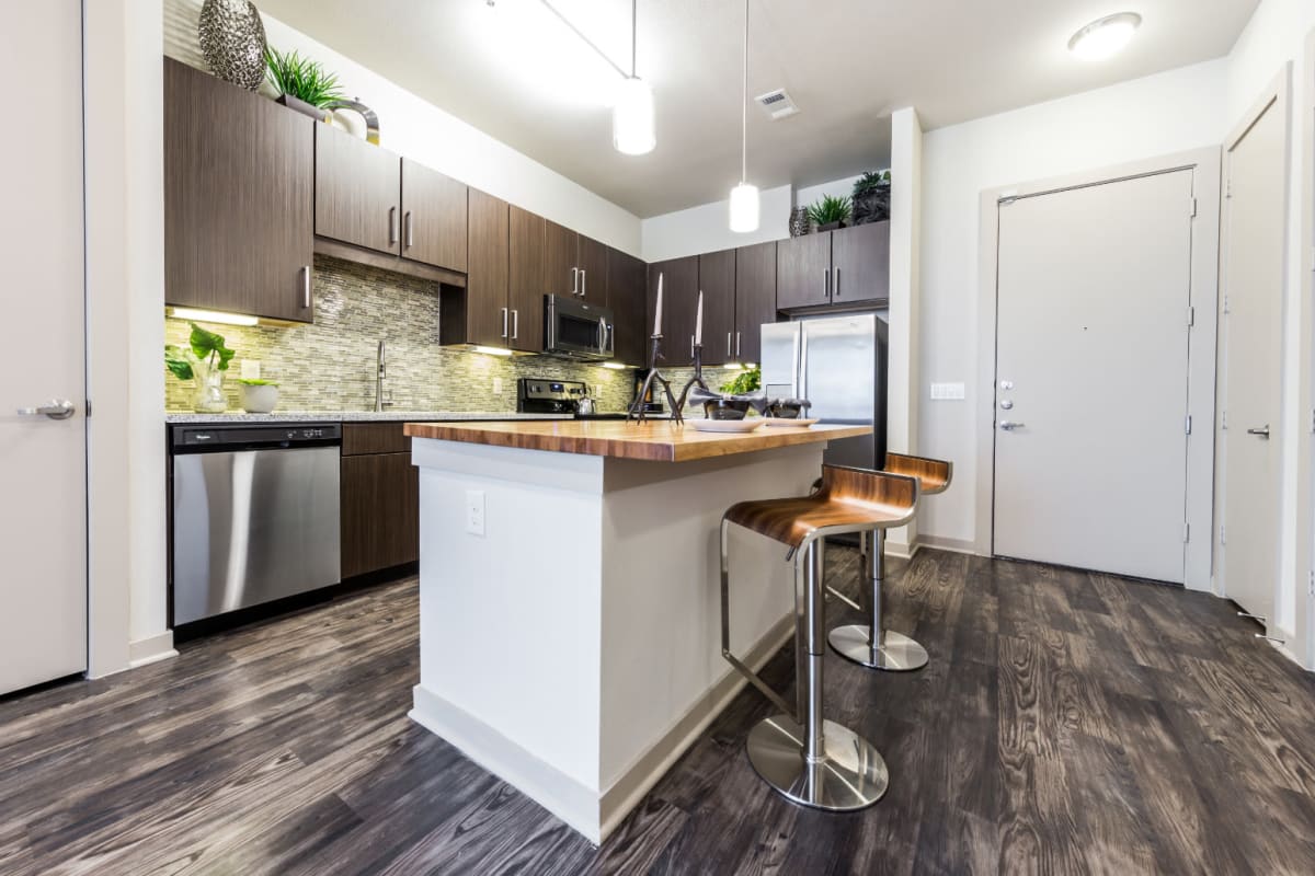 Modern style kitchen with island and counter stools at Marq Uptown in Austin, Texas