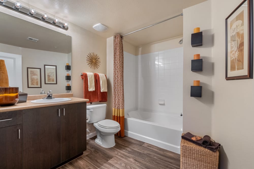 Desert tone style bathroom with wood flooring and bathtub at Marquis at Sonoran Preserve in Phoenix, Arizona