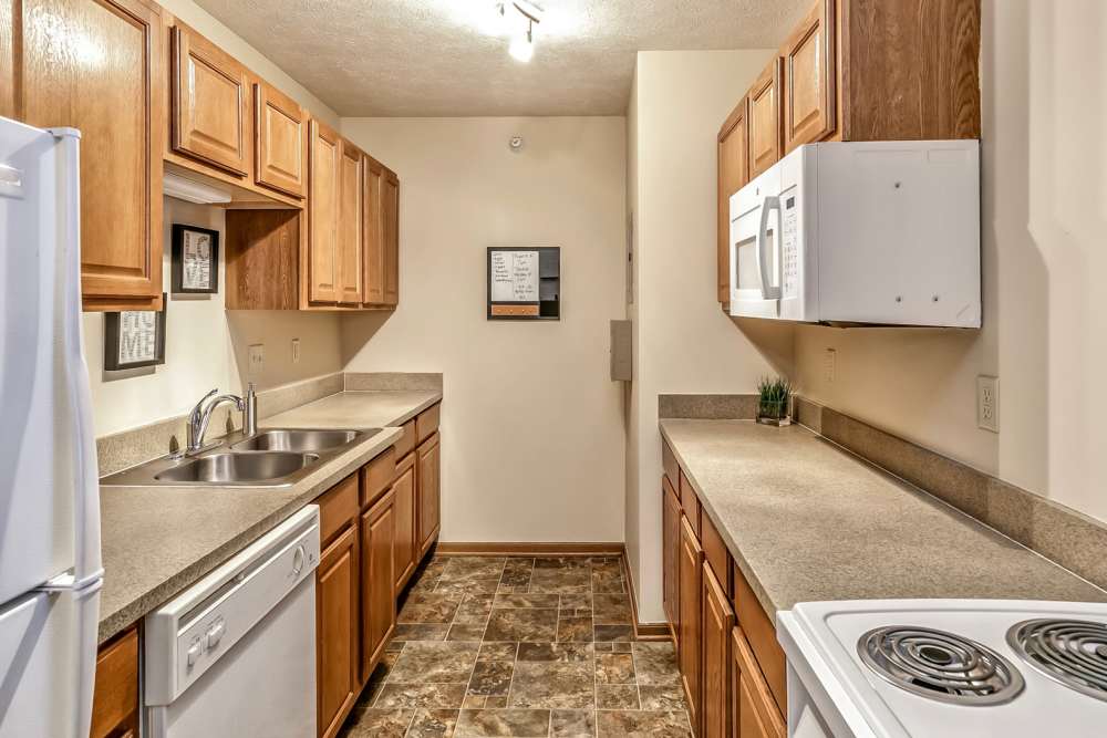 Kitchen with wooden cabinets at The Falgrove Apartments in Omaha, Nebraska