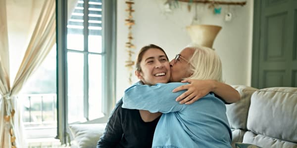 Resident embracing a smiling caretaker at a WISH community