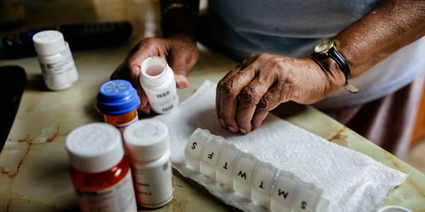 Resident sorting various assorted medications on a table at East Troy Manor in East Troy, Wisconsin