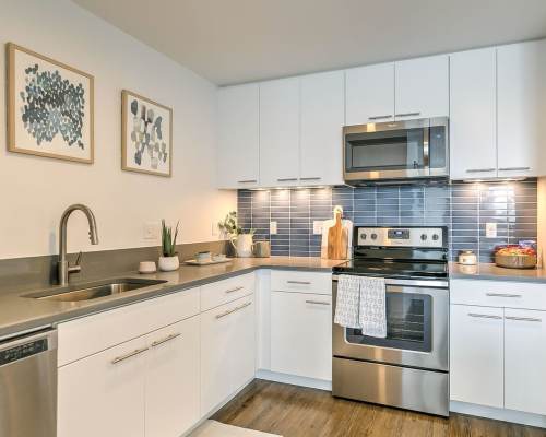 A modern kitchen with cabinets, stainless steel appliances and a dark countertop at The Fowler in Boise, Idaho
