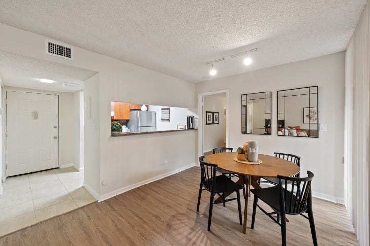 Dining area and kitchen with pass-through window at New Barn Apartments in Miami Lakes, Florida