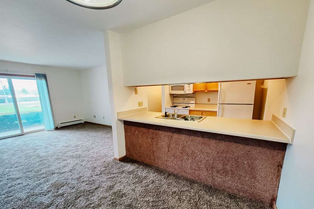 Combined view of kitchen and living room at Rivercrest Apartments in Croswell, Michigan