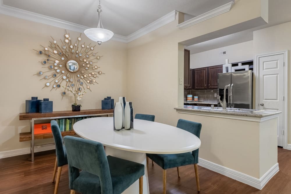 Round dining table and chairs overlooking kitchen at Marquis at Kingwood in Kingwood, Texas