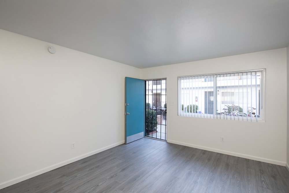 Front entry into apartment with wood style flooring at Ocean Palms Apartments in San Diego, California