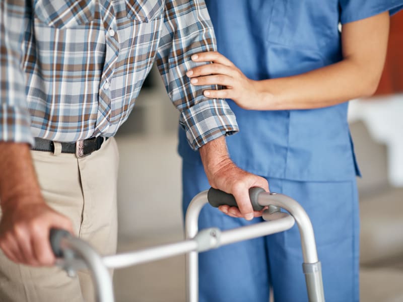 Caretaker assisting a resident with mobility issues at Geneva Lake Manor in Lake Geneva, Wisconsin