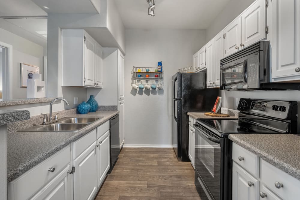 Lighted kitchen with granite counters and modern appliances at Alante at the Islands in Chandler, Arizona