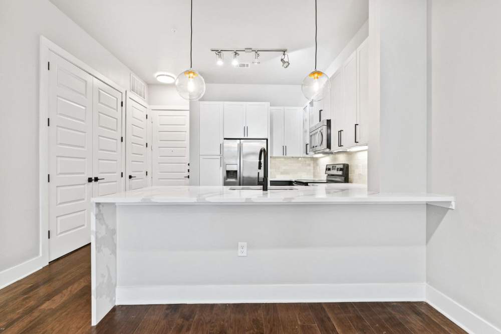 Open apartment kitchen with stainless-steel appliances at Kade in Dallas, Texas