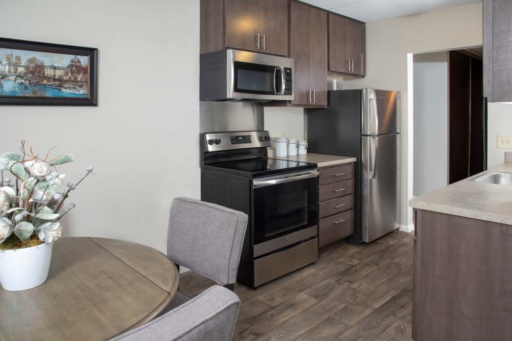 A kitchen with modern stainless steel appliances and access to the dinning area at Meadowview Apartments in Anoka, Minnesota