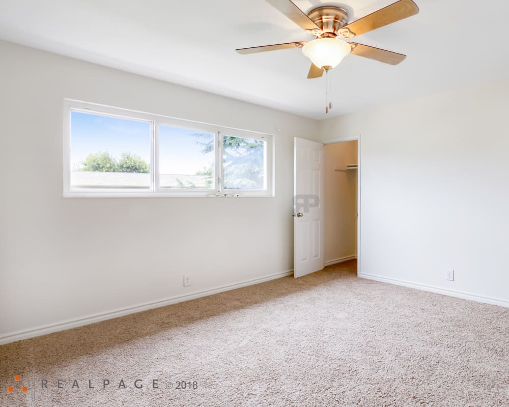 Spacious bedroom with carpet at Washington Townhomes in San Lorenzo, California