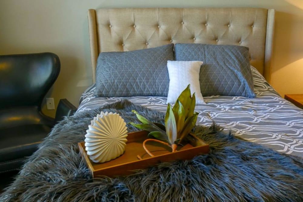 Model bedroom with cozy furnishings at The BLVD in San Angelo, Texas