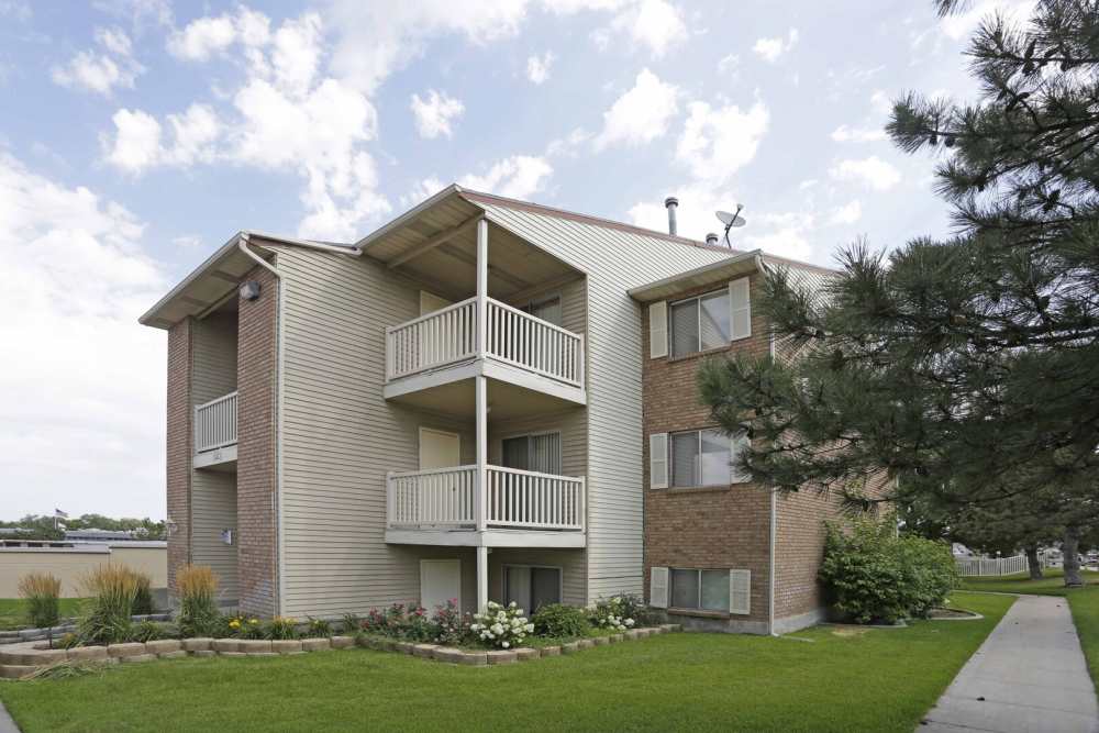 Exterior of an apartment building and patios at Chadds Ford Apartments in Midvale, Utah