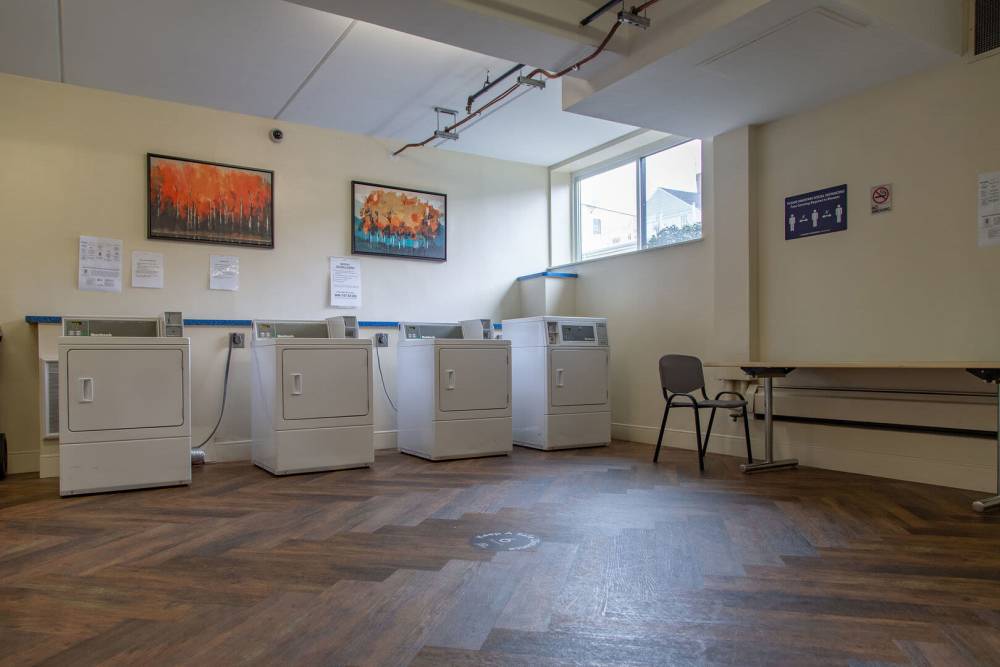White washing machines and wooden floor at Victory Gardens in East Boston, Massachusetts