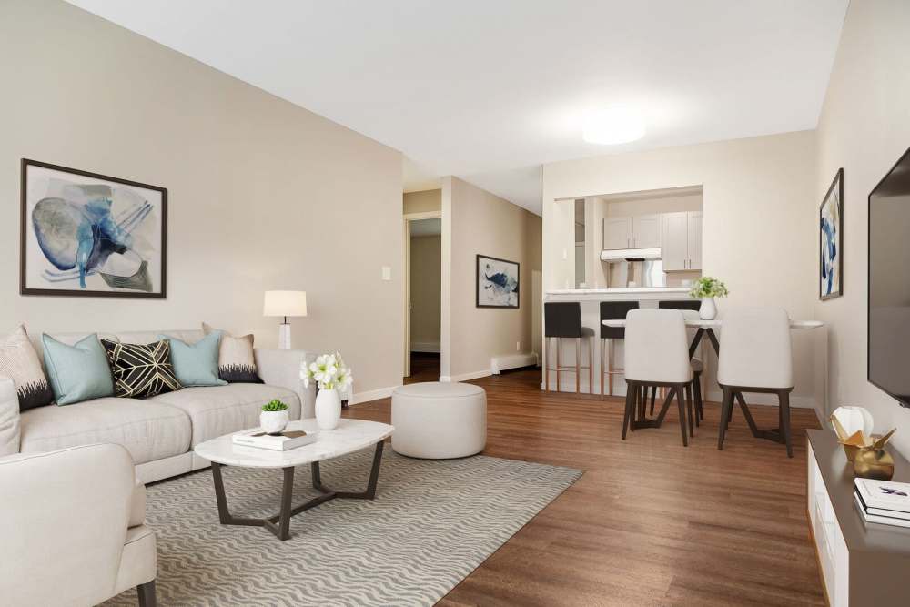 Living room with wood-style flooring and view to kitchen at Powdermill Village in Westfield, Massachusetts