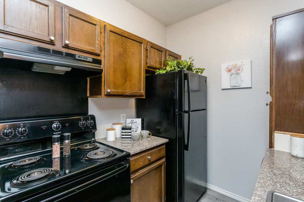 Kitchen with black appliances at Green Tree Place in Houston, Texas