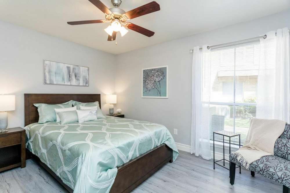 Spacious bedroom with a large bed and ceiling fan at Ridge Point in Houston, Texas