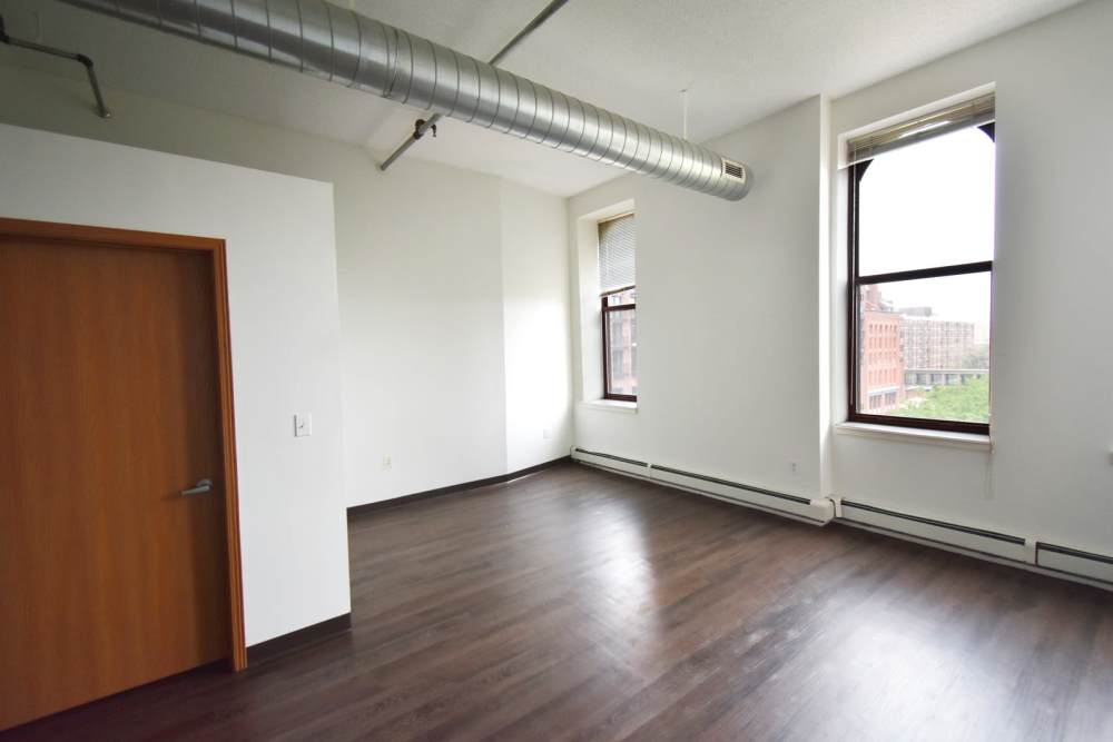 Empty room with hardwood floor and windows at Straus Lofts in Saint Paul, Minnesota