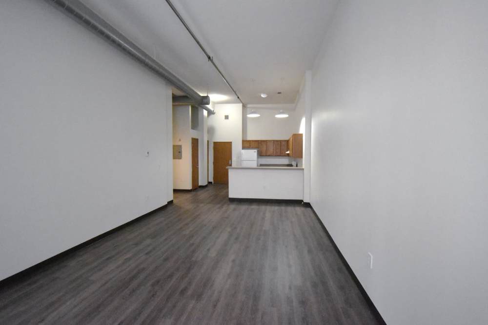 Open space with wood flooring and kitchen area at Straus Lofts in Saint Paul, Minnesota