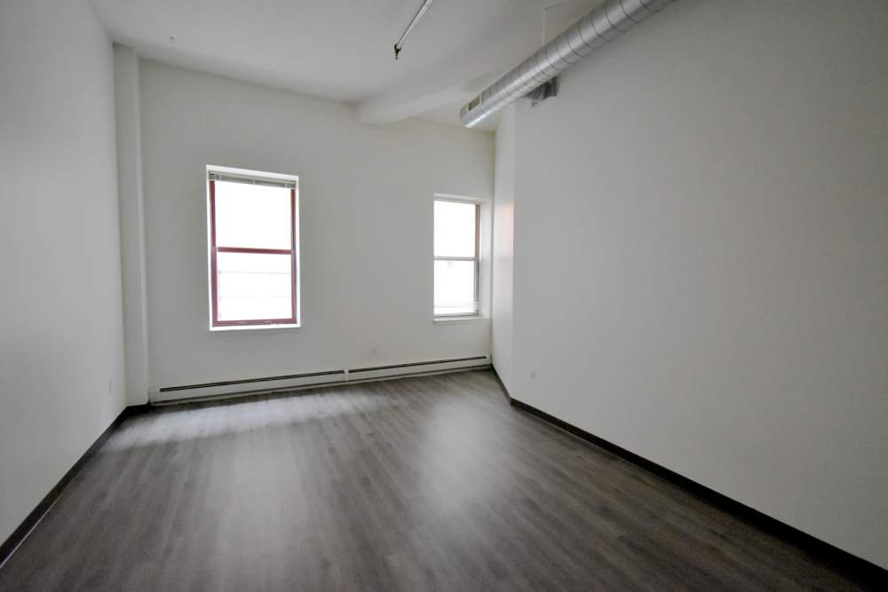 Empty room with two windows and wood flooring at Straus Lofts in Saint Paul, Minnesota