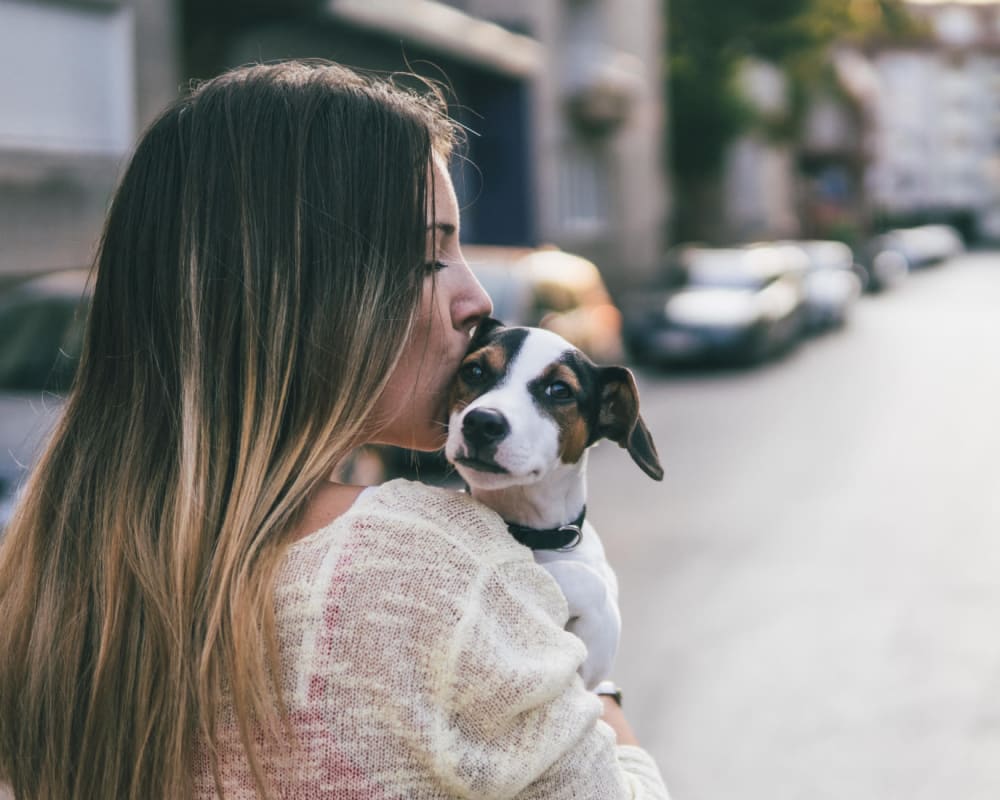 Resident holding her puppy outside of her apartment at The Villas at Woodland Hills in Woodland Hills, California