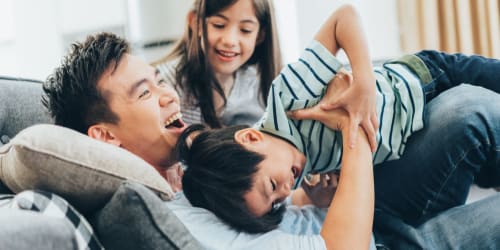 Resident family goofing around in their living room at Twin Manor in South San Francisco, California