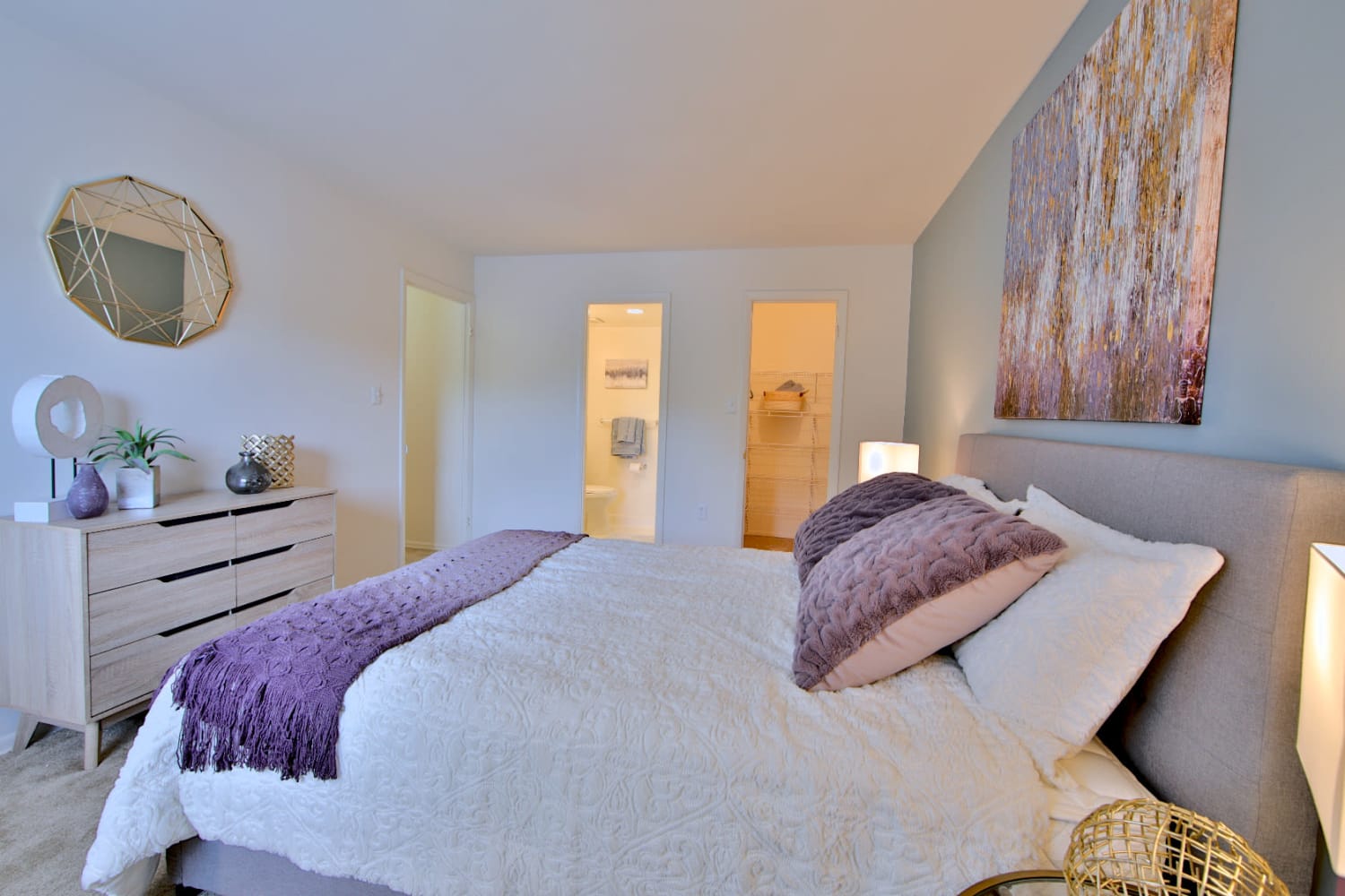 Model bedroom with a walk-in closet and ensuite bathroom at Stoneridge at Mark Center Apartment Homes in Alexandria, Virginia