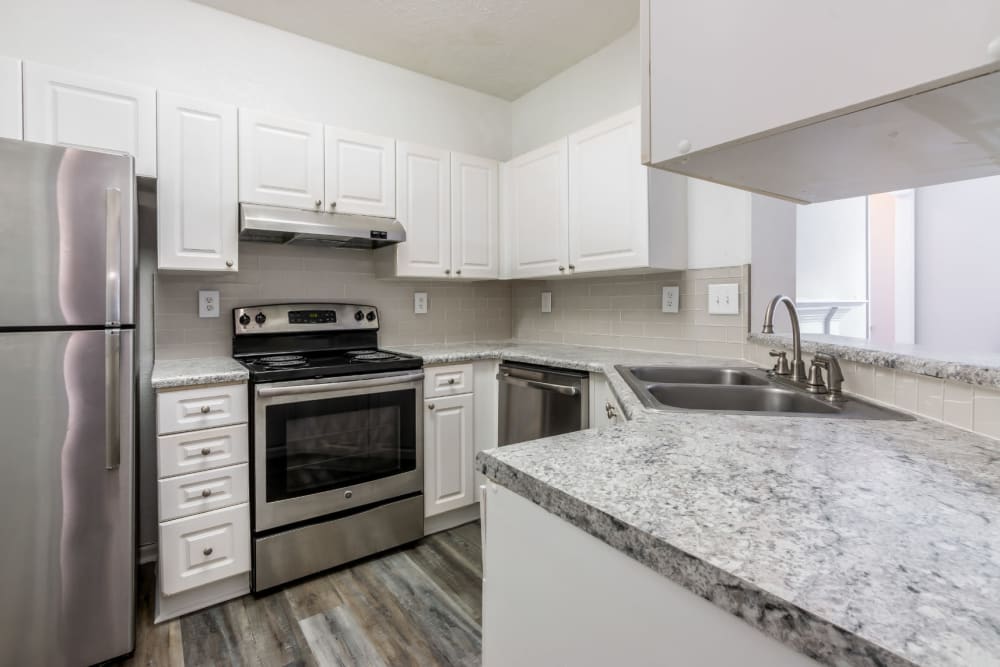 Bright kitchen with wood flooring and stainless steel appliances at Marquis at Sugarloaf in Duluth, Georgia