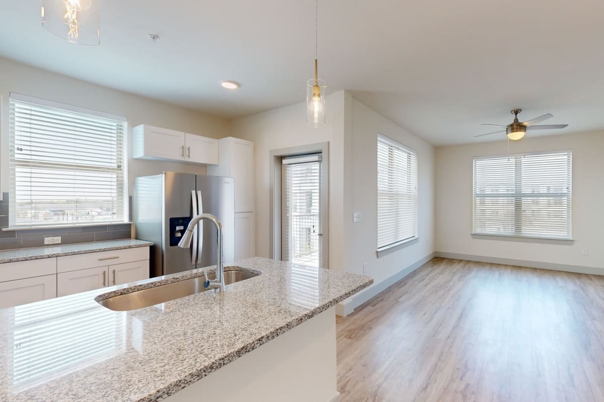 Open kitchen and living room with wood-style flooring at The Grand At Saginaw in Saginaw, Texas