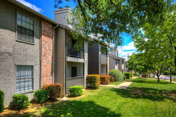 Lush grass and trees outside an apartment building at Canyon Grove in Grand Prairie, Texas