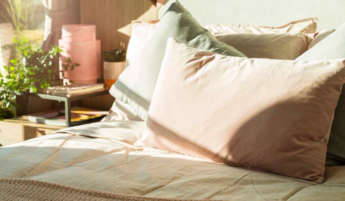 Vibrant bedroom retreat with plush pillows and warm sunlight cascading over cozy linens at Loop Commons in Lafayette, Louisiana.