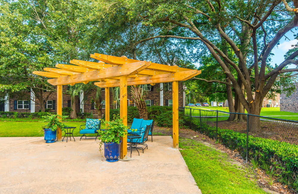 Lush garden with charming pergola and comfortable seating area at Avian Place Apartments in North Charleston, South Carolina