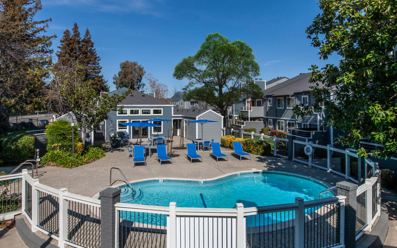 Blue lounge chairs by the pool at Bennington Apartments in Fairfield, California