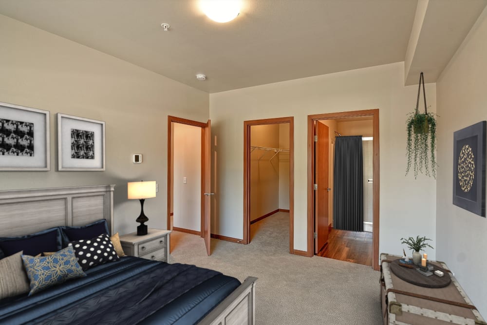 Spacious model bedroom with walk-in closet and ensuite bathroom at Courtyard 465 Apartments in Wenatchee, Washington