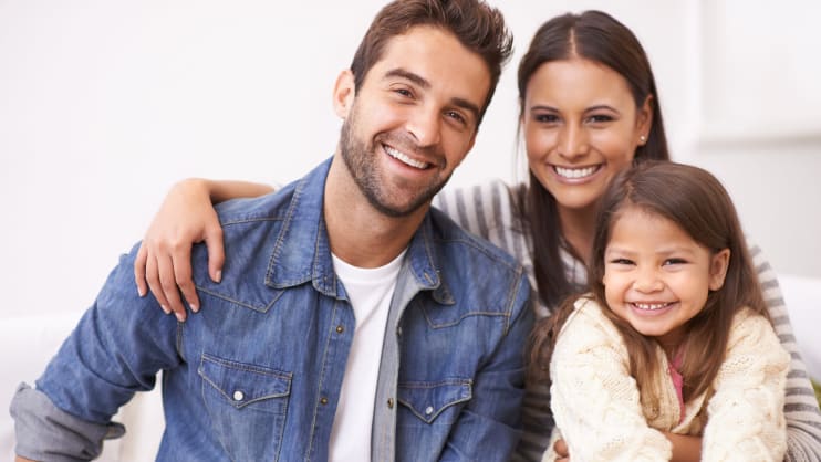 Dad, mom, and daughter smiling