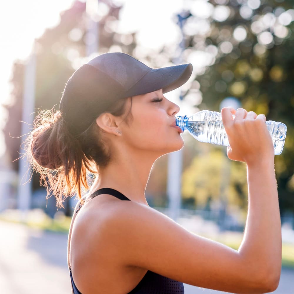 Resident taking a break from her morning run to hydrate near Oaks Glen Lake in Minnetonka, Minnesota