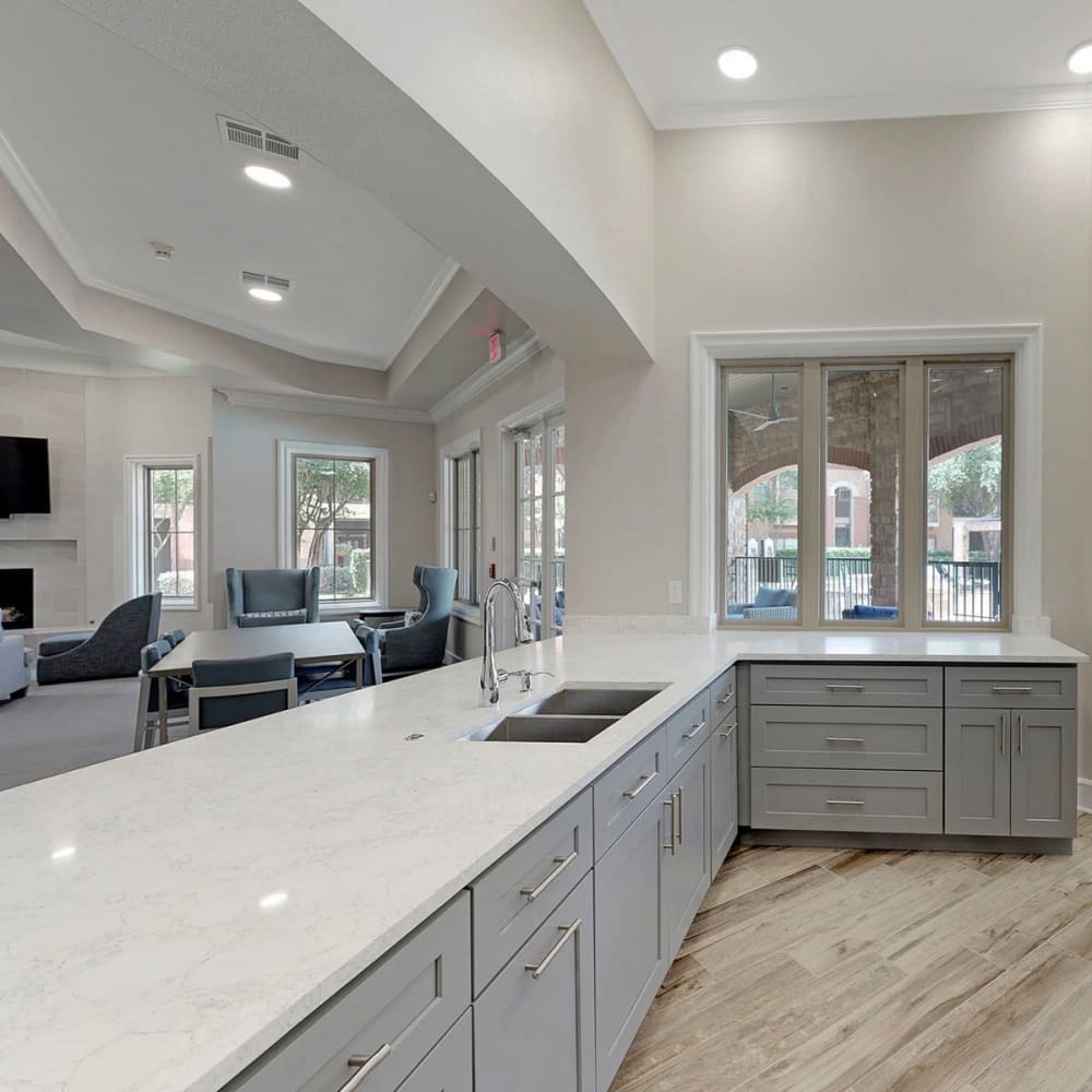 View of the clubhouse lounge over the demonstration kitchen's bar at Oaks Riverchase in Coppell, Texas