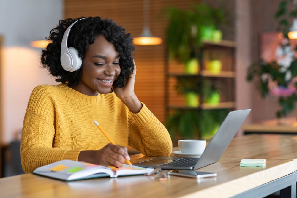 Student getting some morning work done on her laptop in the comfort of her new apartment at Thirteen15 in New Orleans, Louisiana