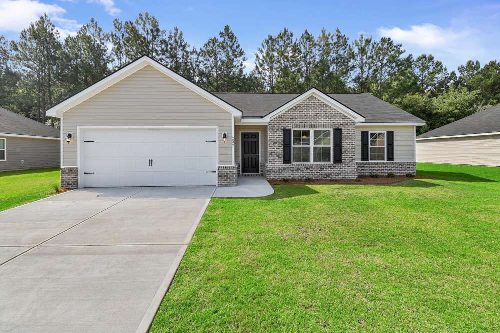 Single-family home with a spacious front yard, two-car garage, and lush green landscaping at Hartford in Statesboro, Georgia