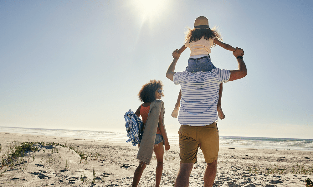 Family going for a walk along the gorgeous beach at Dragas Home Rentals in Virginia Beach, Virginia