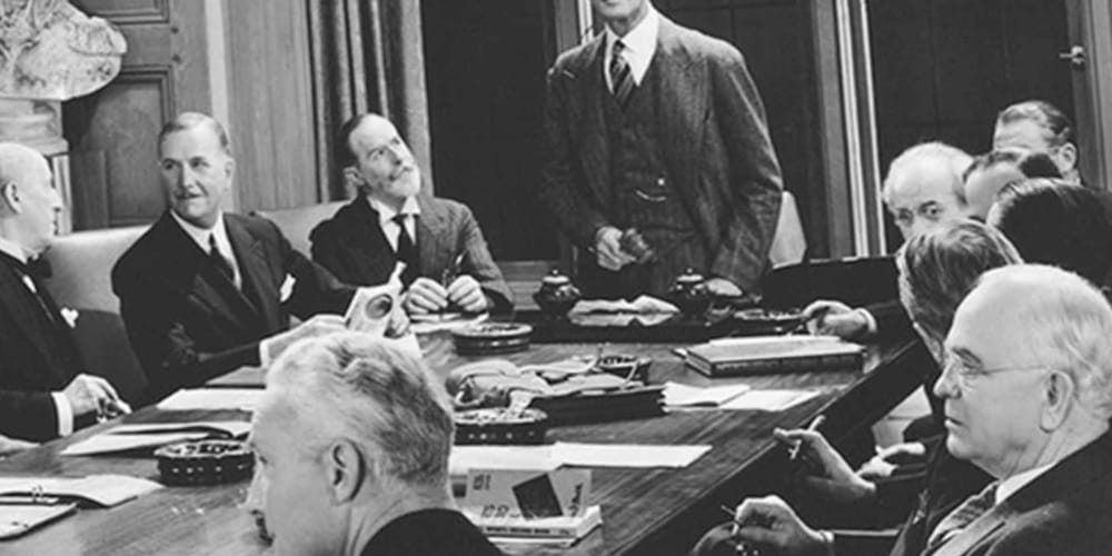 Black and white photo of businessmen sitting around a table at Drucker + Falk in Newport News, Virginia