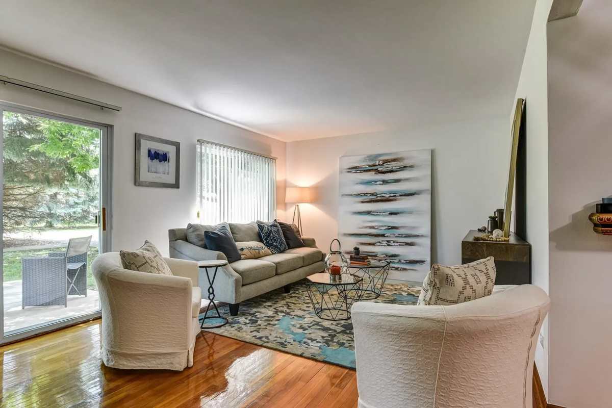 Bright and open living room with carpet and large window at Park Ridge Commons in Des Plaines, Illinois