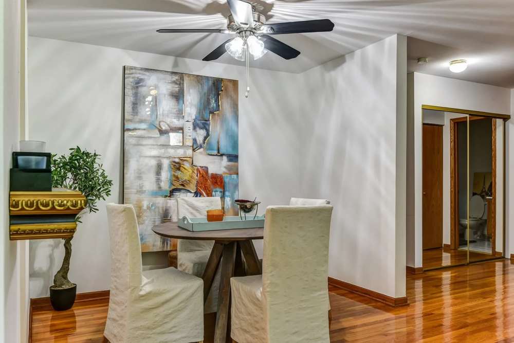 Dining room with a table, couple of chairs and a fan at Park Ridge Commons in Des Plaines, Illinois