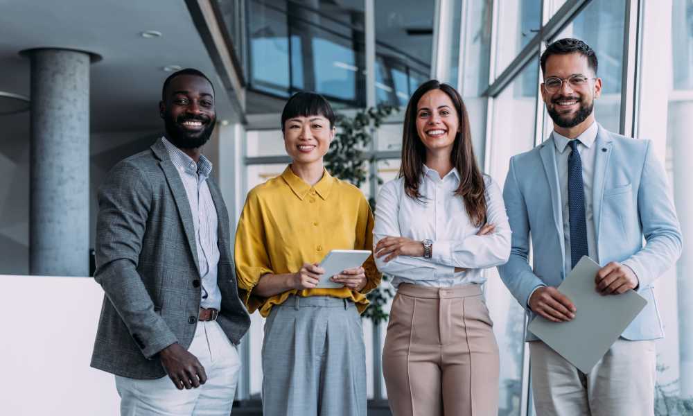 Happy team group of smiling colleagues at ARTISAN Management Group in Des Moines, Iowa