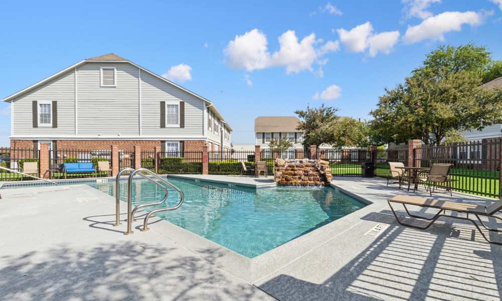 Sparkling pool with lounge chairs at Arbors of Taylor in Taylor, Texas